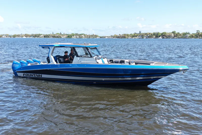 The Image of 2024 Fountain 38 SCX boat on calm water, showcasing sleek design and vibrant blue color. - 0