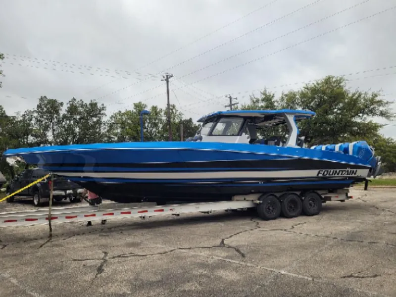 The Image of 2024 Fountain 38 SCX boat in blue on a trailer. - 1