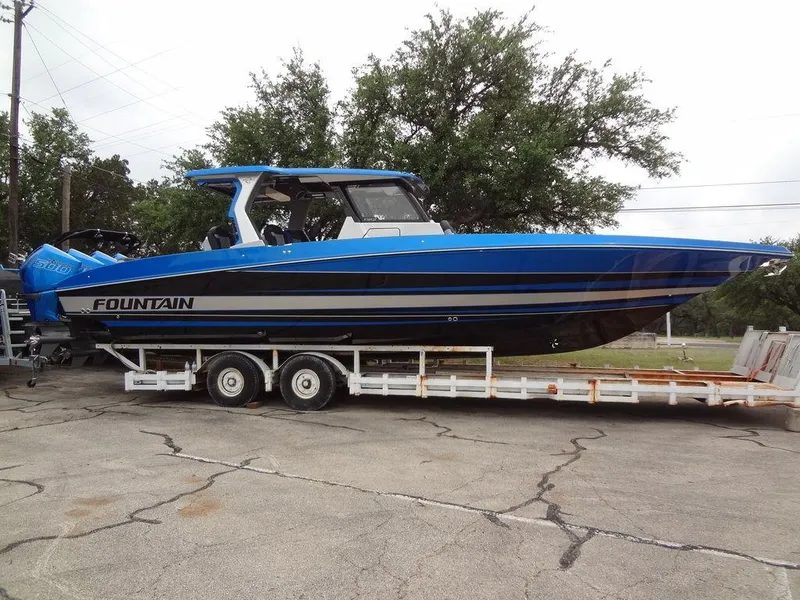 Slide: The Image of 2024 Fountain 38 SCX boat on a trailer, blue and black design. - 11