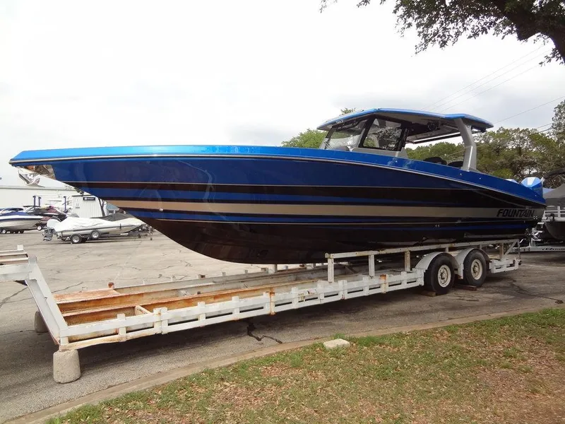 Slide: The Image of 2024 Fountain 38 SCX boat on a trailer, blue and black. - 19