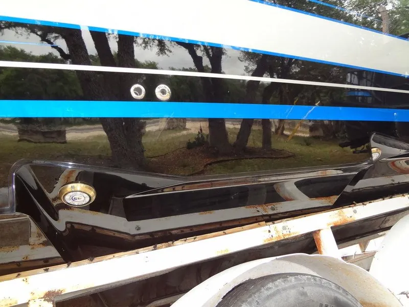 Slide: The Image of 2024 Fountain 38 SCX boat hull with blue and black stripes on a trailer. - 21
