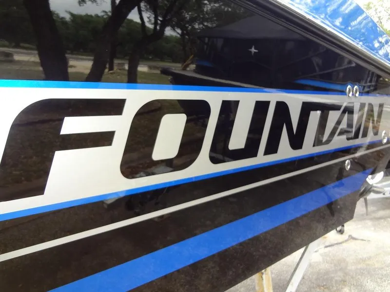 Slide: The Image of Close-up of 2024 Fountain 38 SCX boat with logo and blue stripes. - 23