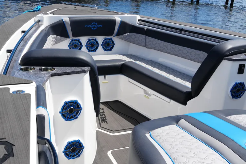 Slide: The Image of 2024 Fountain 38 SCX boat interior with luxurious seating and blue-accented speakers. - 26