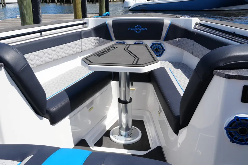 Slide: The Image of 2024 Fountain 38 SCX boat interior with seating and table, docked by the water. - 28