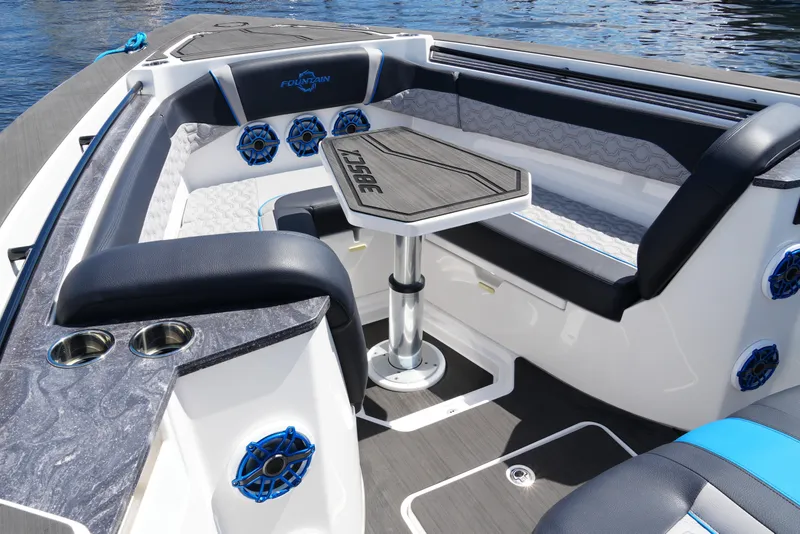 Slide: The Image of 2024 Fountain 38 SCX boat interior with seating, table, and speakers on the water. - 30