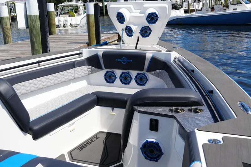 Slide: The Image of 2024 Fountain 38 SCX boat interior with luxury seating and marine speakers at a dock. - 32