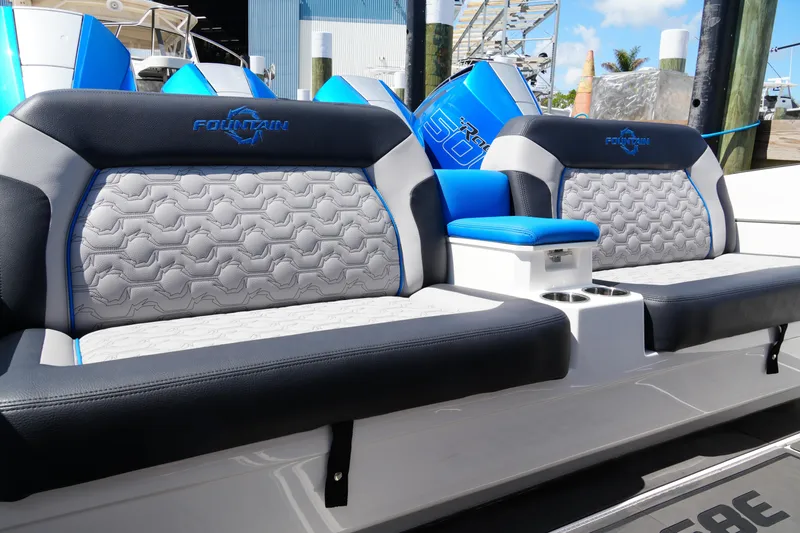 Slide: The Image of 2024 Fountain 38 SCX boat seating with blue and gray upholstery, docked at marina. - 40
