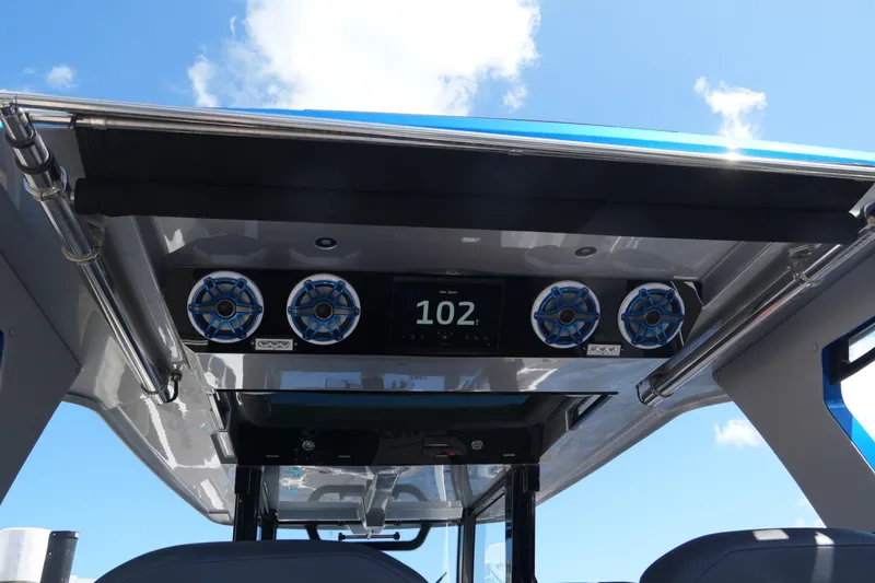 Slide: The Image of 2024 Fountain 38 SCX boat dashboard with speakers and digital display under blue sky. - 43