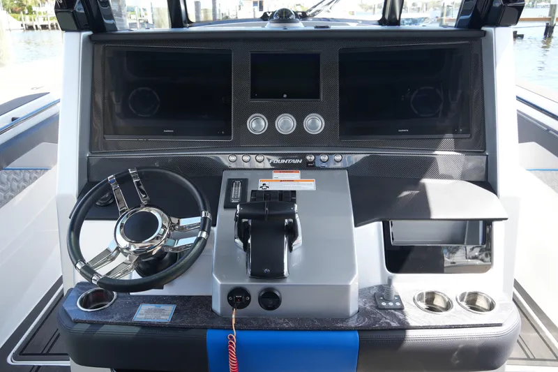 Slide: The Image of 2024 Fountain 38 SCX boat dashboard with steering wheel and dual displays. - 51