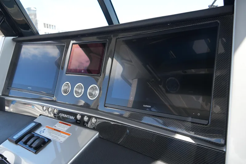 Slide: The Image of 2024 Fountain 38 SCX dashboard with Garmin displays and carbon fiber finish. - 52