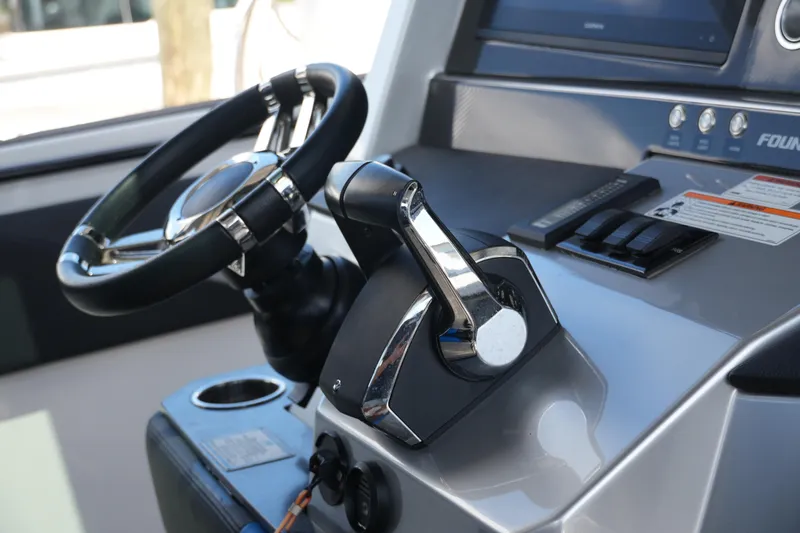 Slide: The Image of 2024 Fountain 38 SCX boat helm with steering wheel and throttle controls. - 54