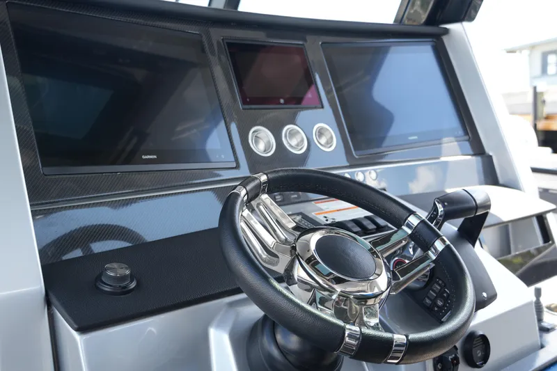 Slide: The Image of 2024 Fountain 38 SCX boat dashboard with modern steering wheel and digital displays. - 55
