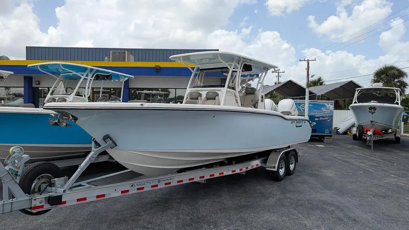 The Image of 2025 Key West 291 FS boat on trailer at dealership, under cloudy sky. - 0