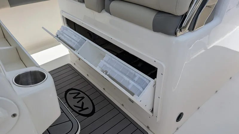 Slide: The Image of 2025 Key West 291 FS boat storage compartment with open hatch and seating area. - 11