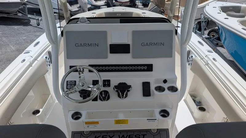Slide: The Image of 2025 Key West 291 FS boat dashboard with dual Garmin displays and steering wheel. - 12