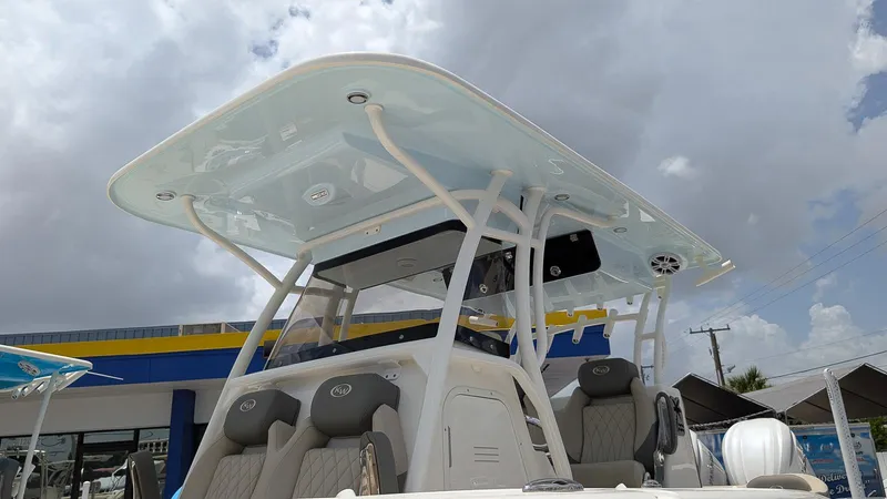 Slide: The Image of 2025 Key West 291 FS boat with T-top and cushioned seats under cloudy sky. - 22