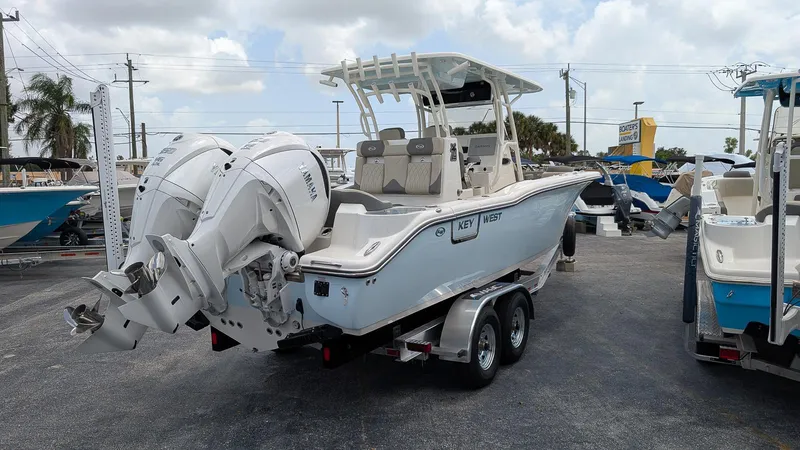 Slide: The Image of 2025 Key West 291 FS boat with dual engines on a trailer in a marina. - 3