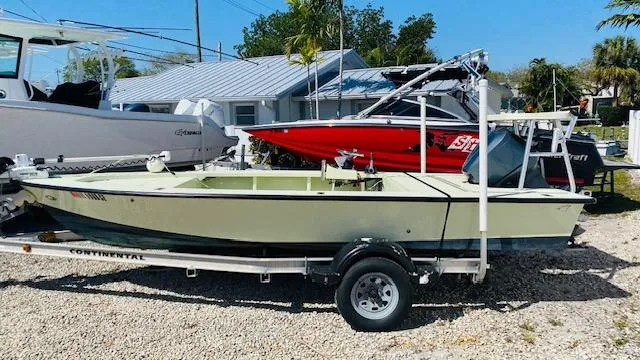 The Image of 1983 Maverick 18 Flats Boat on trailer, parked outdoors near other boats. - 0
