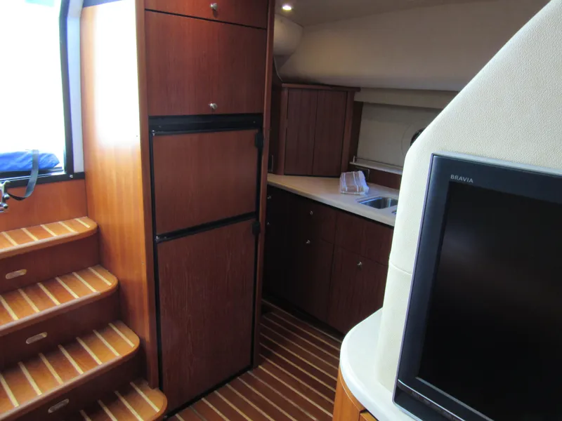 Slide: The Image of 2006 Tiara Yachts 4300 Sovran interior with wooden cabinetry, stairs, and a flat-screen TV. - 15