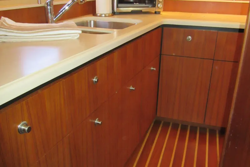 Slide: The Image of 2006 Tiara Yachts 4300 Sovran galley with wood cabinets and modern sink. - 16
