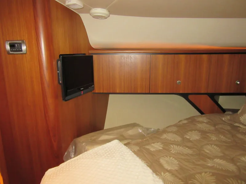 Slide: The Image of 2006 Tiara Yachts 4300 Sovran cabin interior with wood paneling and mounted TV. - 18
