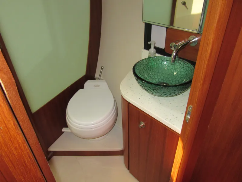 Slide: The Image of 2006 Tiara Yachts 4300 Sovran bathroom with modern glass sink and wooden cabinetry. - 19