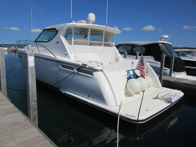 Slide: The Image of 2006 Tiara Yachts 4300 Sovran docked, featuring sleek design and American flag. - 2