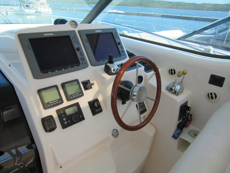 Slide: The Image of 2006 Tiara Yachts 4300 Sovran helm with navigation instruments and wooden steering wheel. - 4
