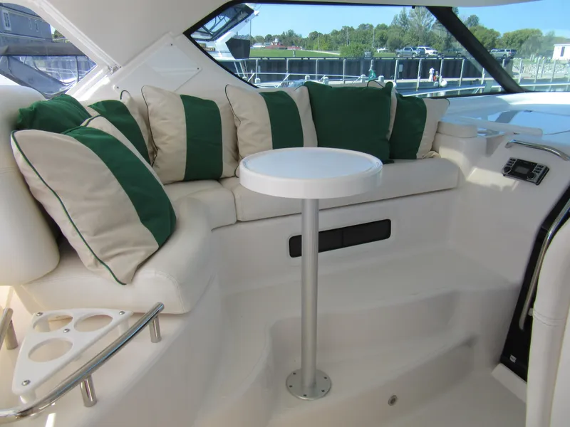 Slide: The Image of 2006 Tiara Yachts 4300 Sovran interior with green-striped cushions and a small round table. - 7