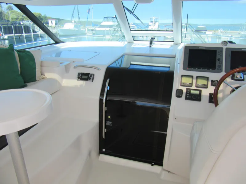 Slide: The Image of 2006 Tiara Yachts 4300 Sovran cockpit with helm, navigation equipment, and seating area. - 8