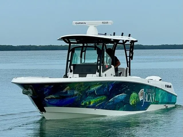 Slide: The Image of 2020 Wellcraft 302 Fisherman boat with colorful marine graphics on calm water. - 1