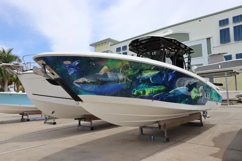 Slide: The Image of 2020 Wellcraft 302 Fisherman boat with vibrant fish-themed hull design. - 5