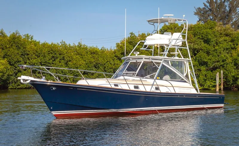 Slide: The Image of 2000 Little Harbor 42 Whisper Jet boat on calm water with lush greenery in the background. - 0