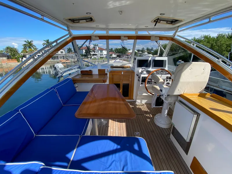 Slide: The Image of Interior of 2000 Little Harbor 42 Whisper Jet with blue seating and wooden table. - 20