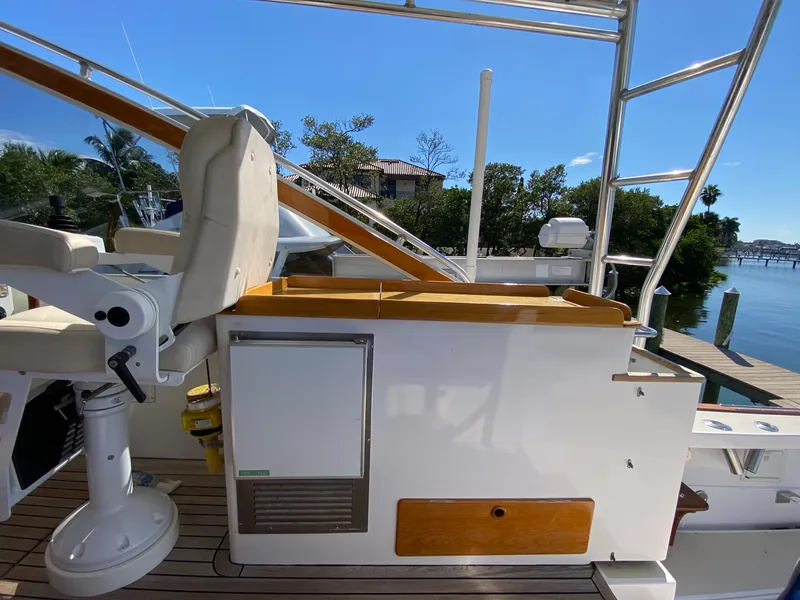 Slide: The Image of 2000 Little Harbor 42 Whisper Jet helm station with seating and storage, docked by the water. - 23