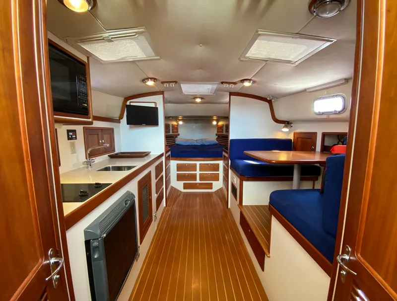 Slide: The Image of Interior of 2000 Little Harbor 42 Whisper Jet yacht with wood finishes and blue seating. - 28