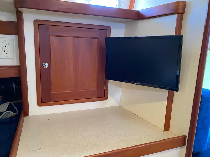 Slide: The Image of Interior of 2000 Little Harbor 42 Whisper Jet with mounted TV and wooden cabinet. - 34