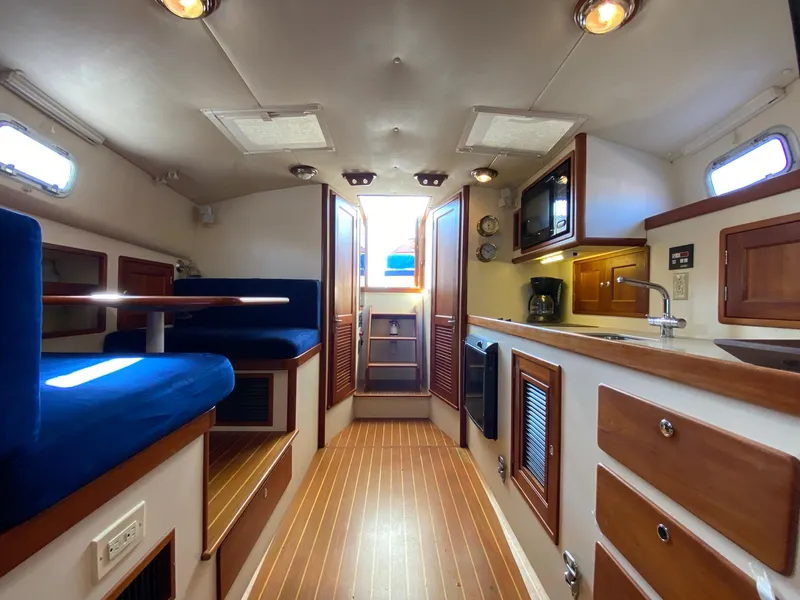 Slide: The Image of Interior of 2000 Little Harbor 42 Whisper Jet yacht with wooden flooring and blue seating. - 35