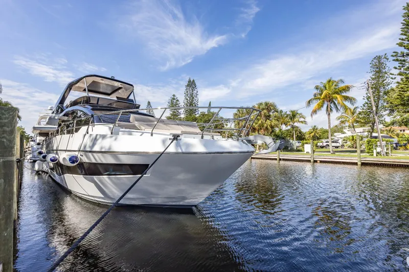 Slide: The Image of 2024 Astondoa Flybridge yacht docked in a serene canal with palm trees. - 10