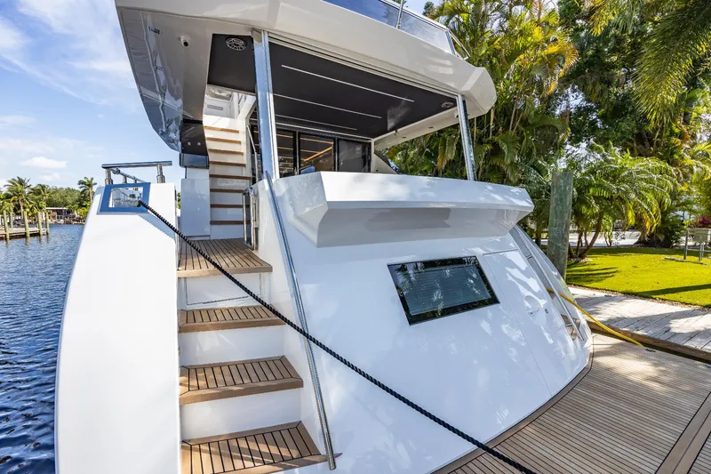 Slide: The Image of 2024 Astondoa Flybridge yacht docked, showcasing elegant design and wooden steps. - 13