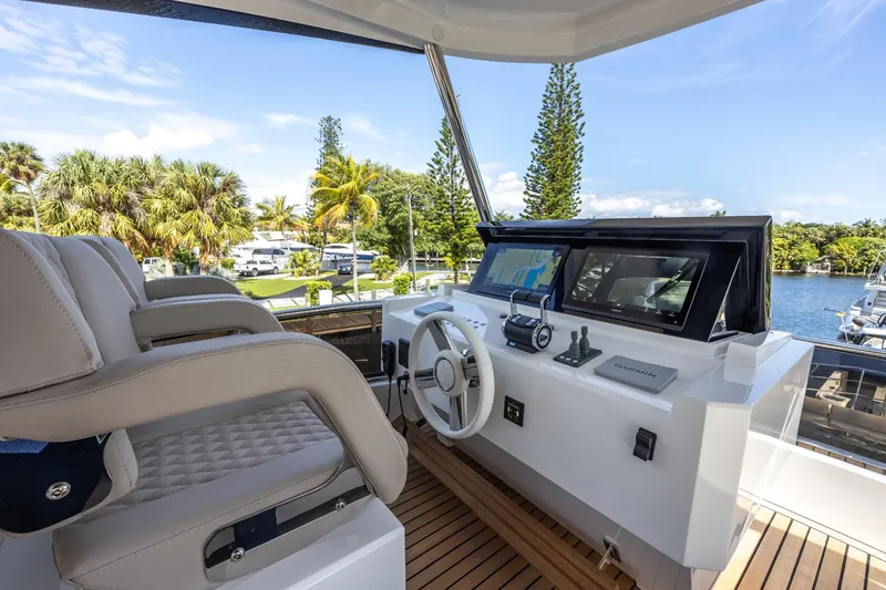 Slide: The Image of 2024 Astondoa Flybridge yacht helm station with dual seats and modern controls. - 17