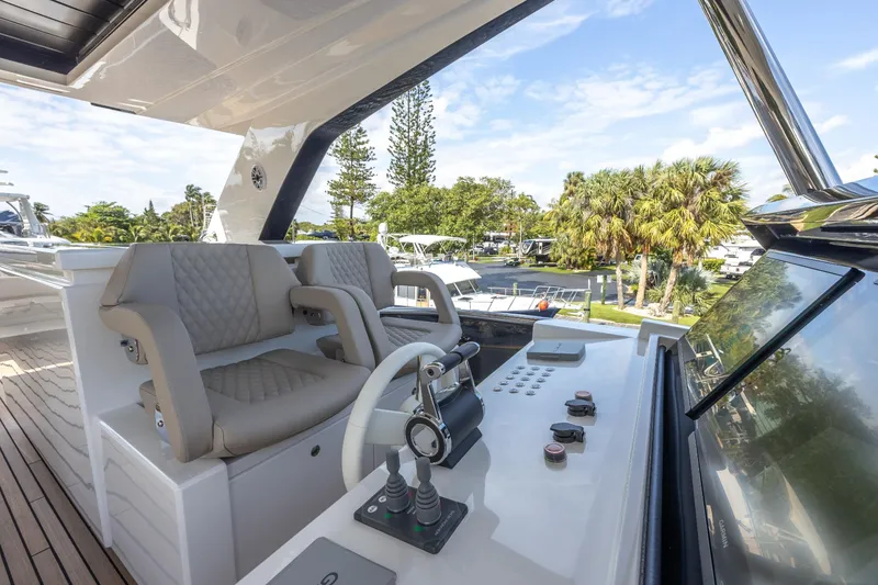 Slide: The Image of 2024 Astondoa Flybridge yacht helm station with dual captain chairs and control panel. - 18