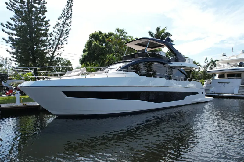 Slide: The Image of 2024 Astondoa Flybridge yacht docked in a serene marina. - 2