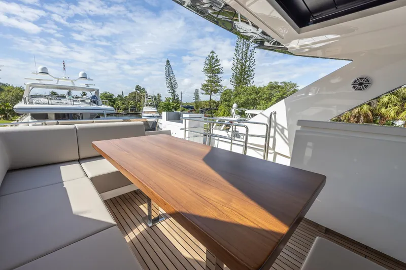 Slide: The Image of 2024 Astondoa Flybridge yacht with outdoor seating and wooden table. - 23