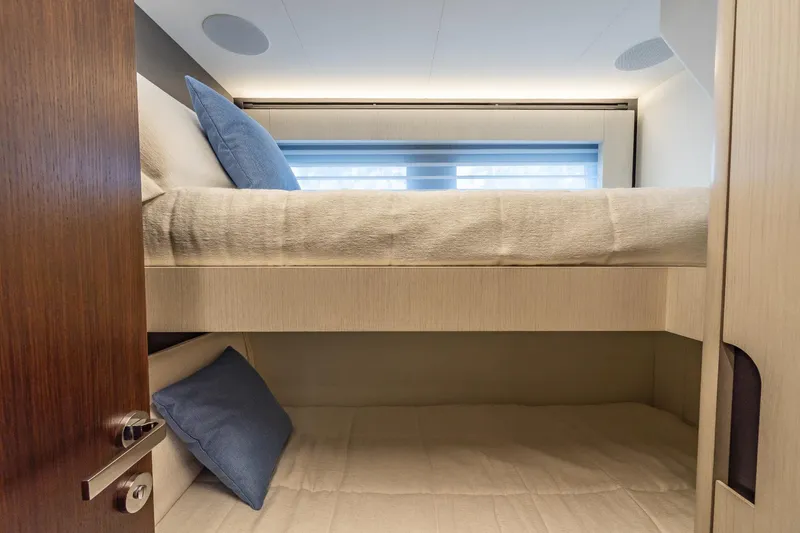 Slide: The Image of 2024 Astondoa Flybridge yacht interior with bunk beds and blue pillows. - 49