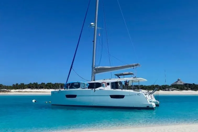 Slide: The Image of 2018 Fountaine Pajot Lucia 40 catamaran anchored in clear turquoise waters. - 0