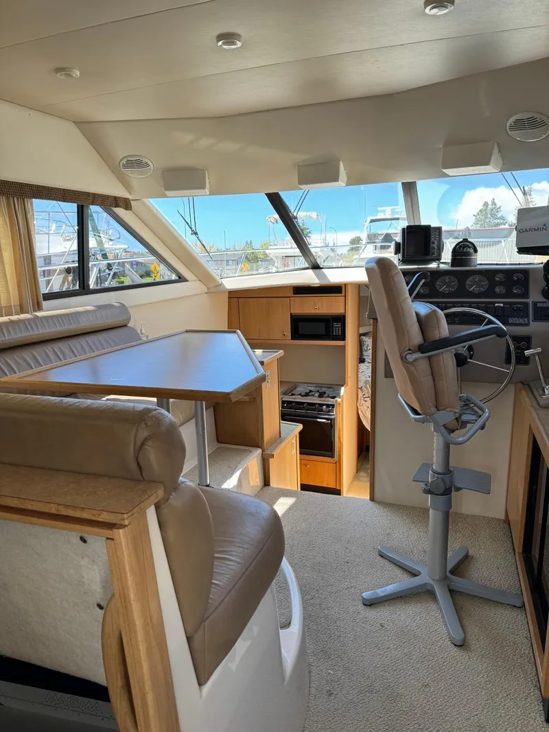 Slide: The Image of Interior of 2000 Bayliner 3388 Motor Yacht with helm, seating, and dining area. - 10