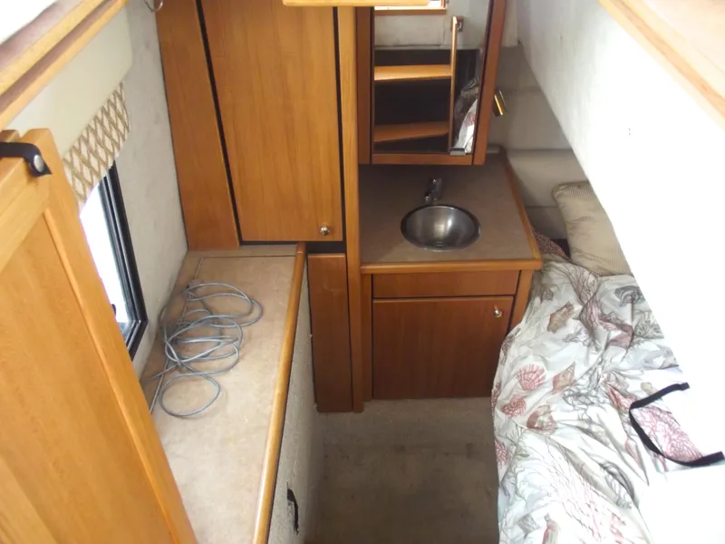 Slide: The Image of Interior of 2000 Bayliner 3388 Motor Yacht with sink, bed, and wooden cabinetry. - 11