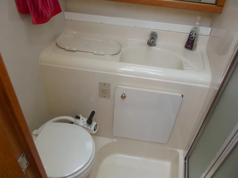 Slide: The Image of Compact bathroom in a 2000 Bayliner 3388 Motor Yacht with sink and toilet. - 25
