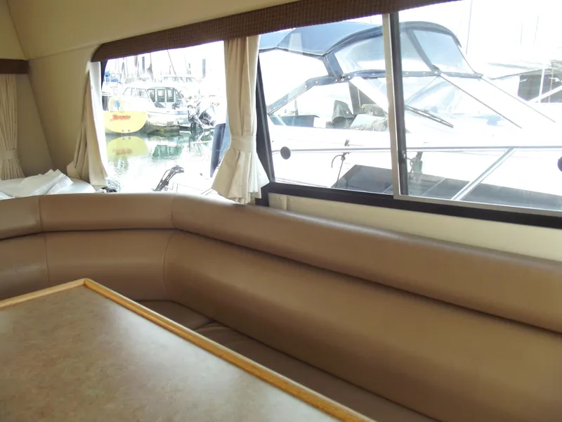 Slide: The Image of Interior of 2000 Bayliner 3388 Motor Yacht with beige seating and marina view. - 29